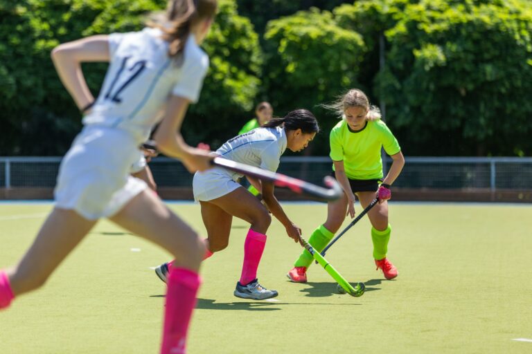 Two female field hockey players fighting for the ball on the pitch